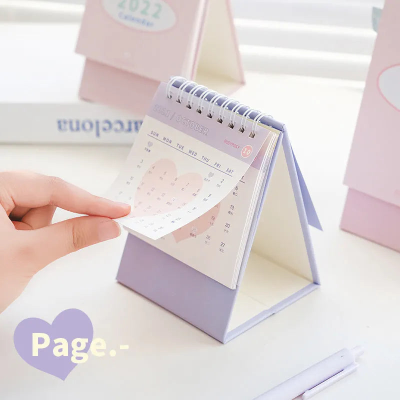 Cream coil desk calendar on a table, regular size 100mm, paper material with year-round date layout