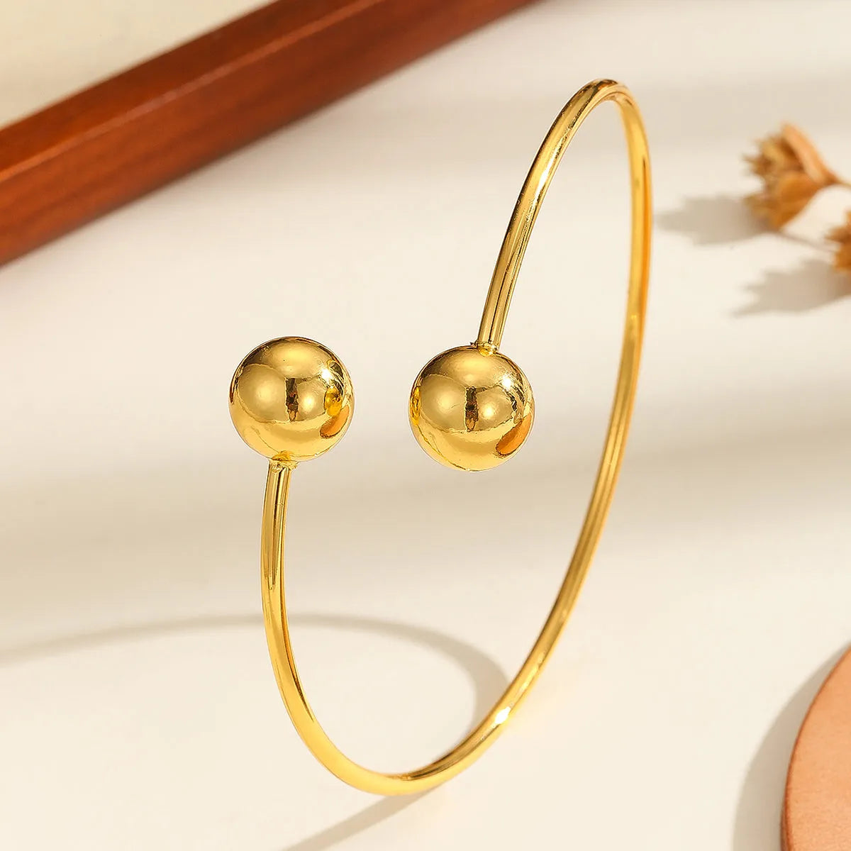 Golden copper plated 18k gold double bead opening bracelet on white background