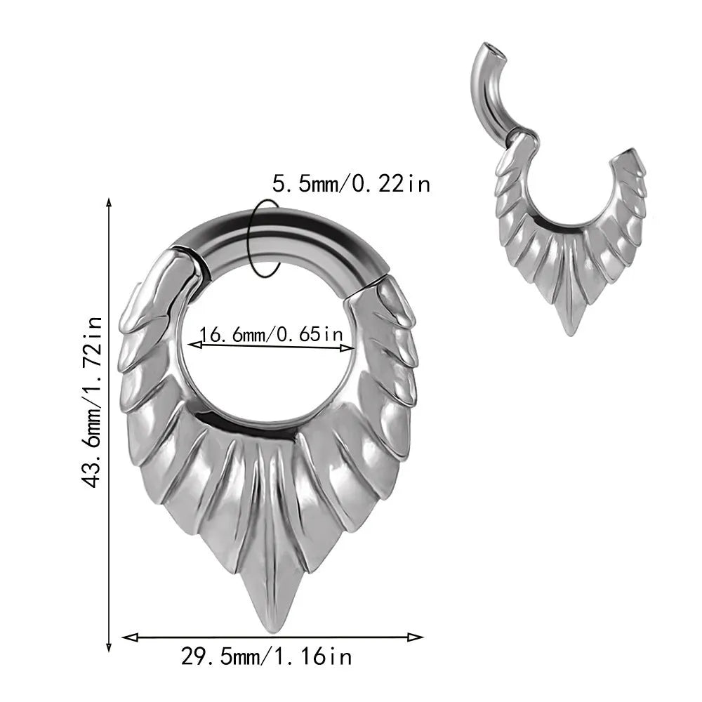 Close-up of a polished silver drop-shaped ear stretcher with a detailed totem pattern, shown against a neutral background.