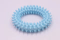 Blue TPR spiky circle ring dog chew toy for teeth cleaning on a white background.