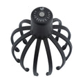 Black electric scalp massager with 12 TPE 3D massage arms on a flat surface