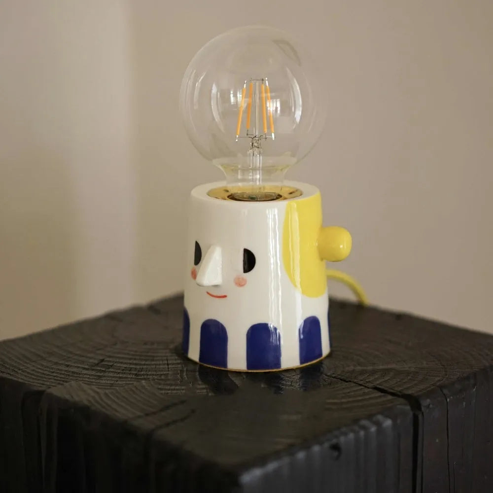 Handmade ceramic table lamp with a white spherical shade on a solid ceramic base, showcasing its simple design.