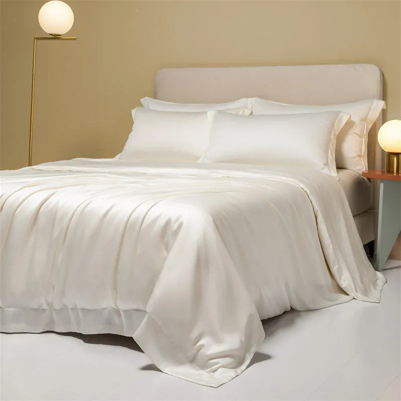 A neatly made bed with a Lenzing Tencel duvet cover and pillowcases in a soft grey colour.