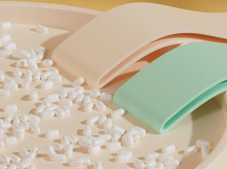 Plastic elastic resistance band in four colours: green, beige, orange, and pink representing different tension levels