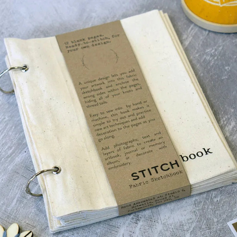 Linen stitch fabric sketchbook in beige square format with ring binding and waist seal