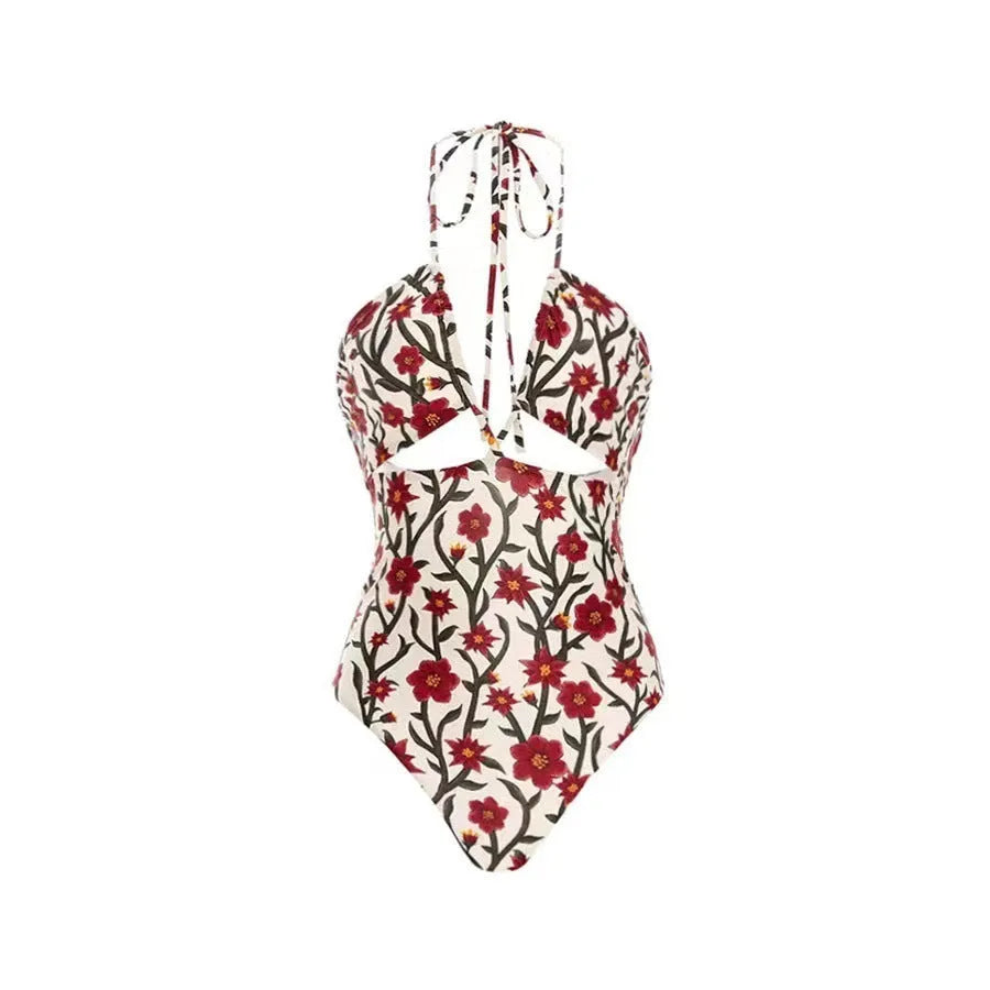 Female model wearing two-piece halter neck swimsuit with floral print and hollow-out gauze skirt cover-up