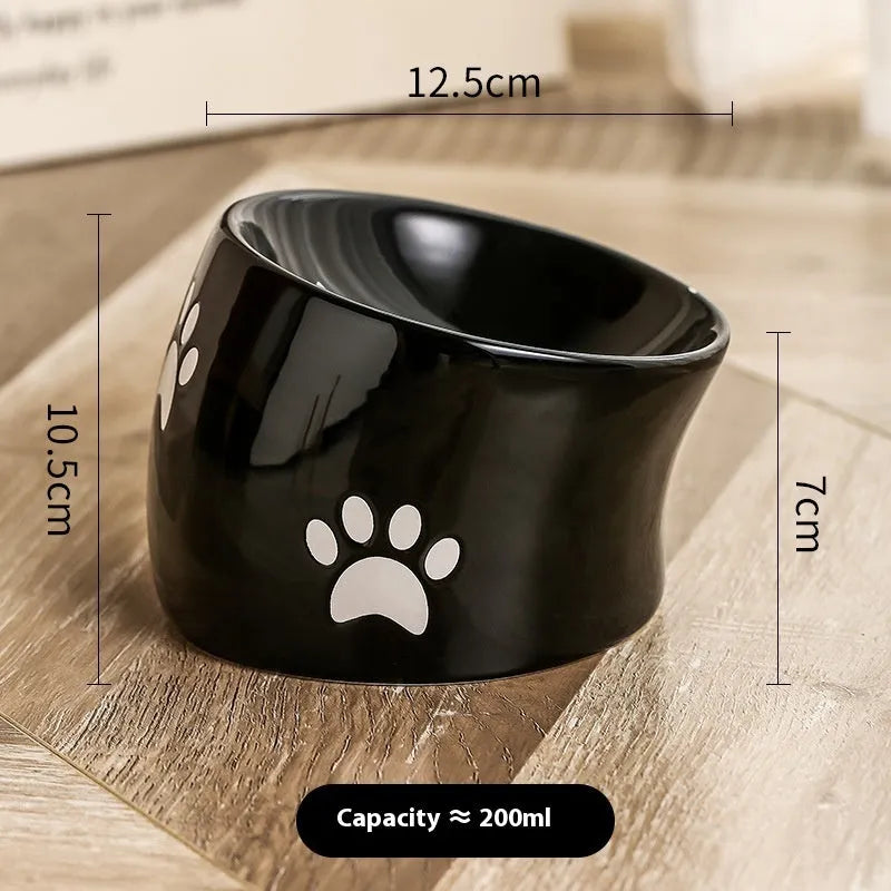 Ceramic cat food bowl with high foot base in a cat's paw print design