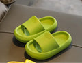 Bright coloured EVA children's house slippers with thick, textured non-slip soles on a wooden floor.