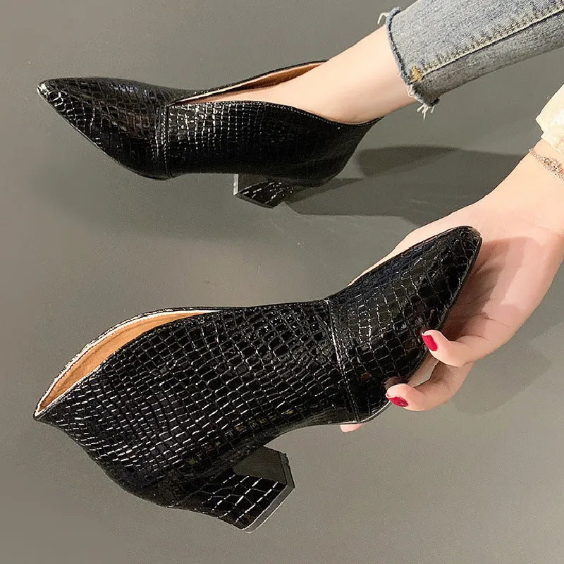 Women's black embossed V-cut Martin boots with a chunky heel on a white background.