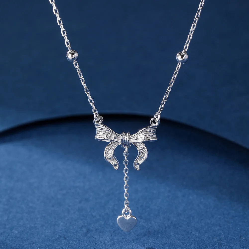 S925 sterling silver necklace with heart and bow pendant on an adjustable O-ring chain.