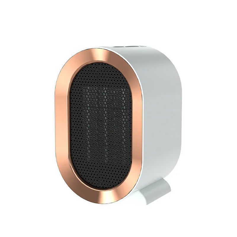 A compact black desktop ceramic fan heater with a mechanical control dial and a UK plug.