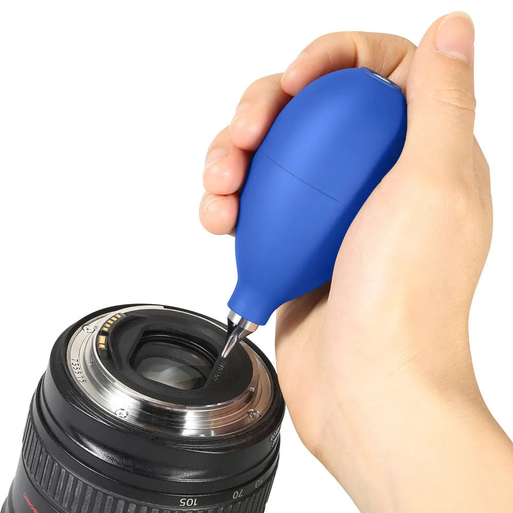 Blue rubber manual air blower for dust removal on a camera lens and mobile phone.