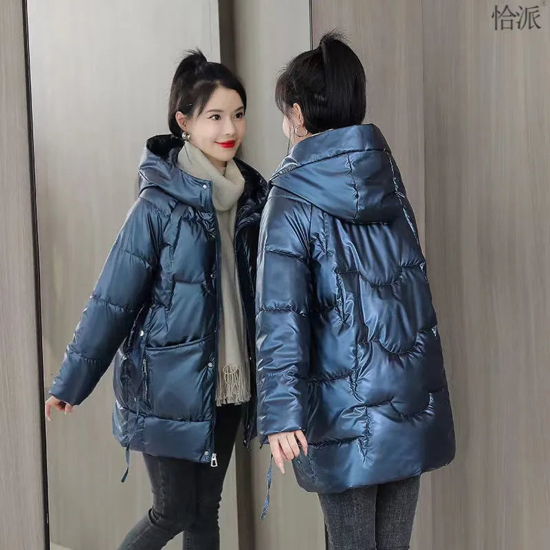 Green loose-fit women's hooded winter jacket with long sleeves on a hanger