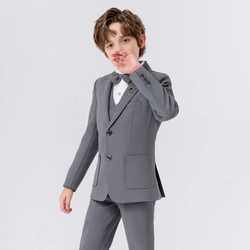 Boy's solid colour British style suit dress set with coat, trousers, vest, bow tie, and brooch on a hanger