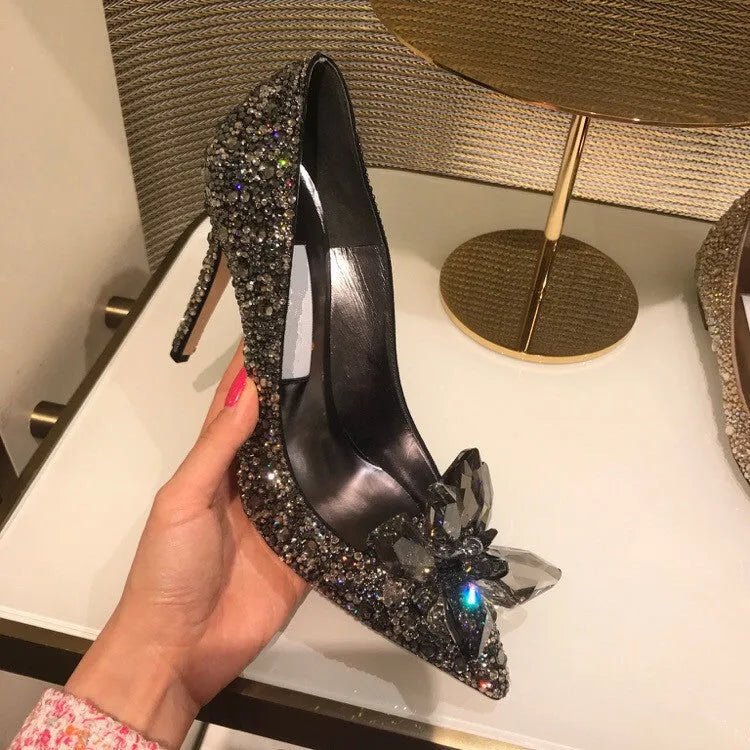Women's gold high heels with pointed toe, rhinestone decoration, and a stiletto heel.