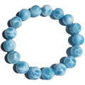 Blue bodhi bracelet with a sea-pattern natural crystal stone and small pearl accents on a wrist.