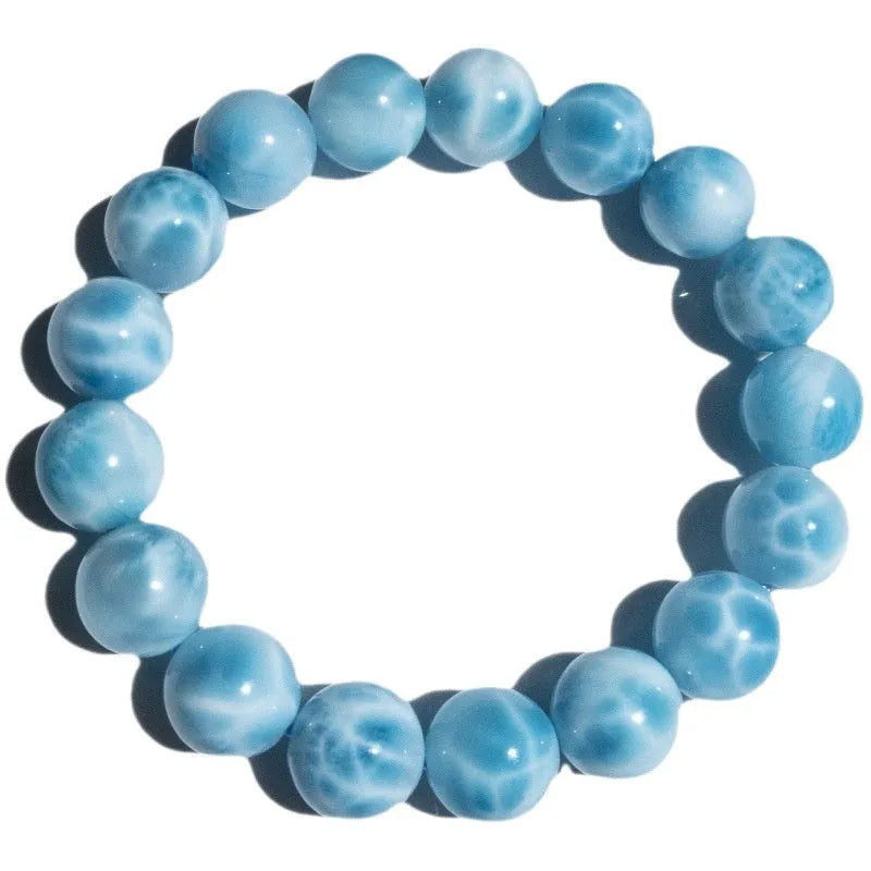 Blue bodhi bracelet with a sea-pattern natural crystal stone and small pearl accents on a wrist.