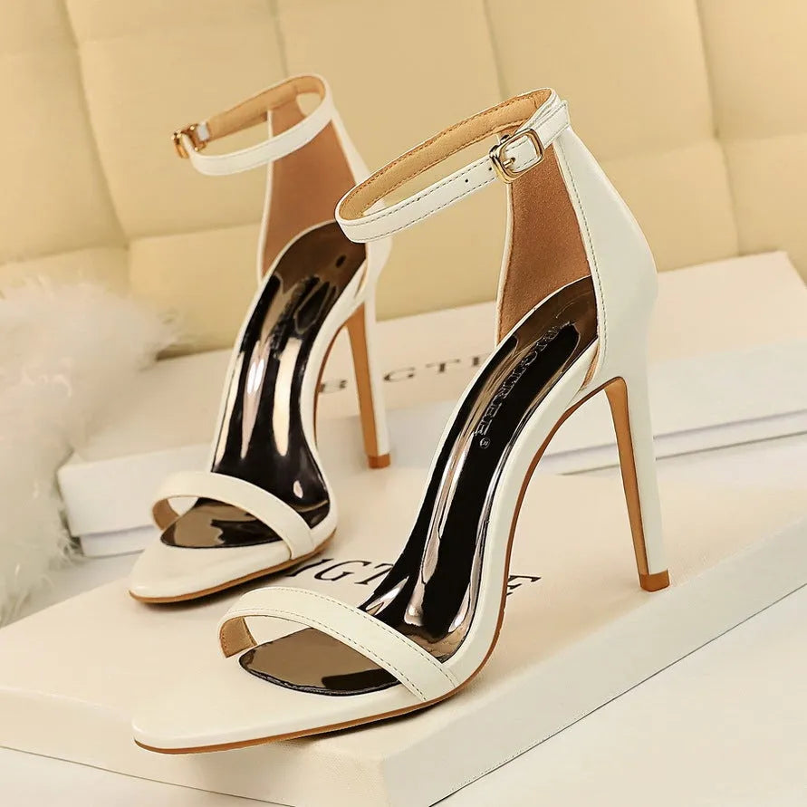 Open-toe high heel with a single ankle strap and buckle fastening, shown in a solid colour.