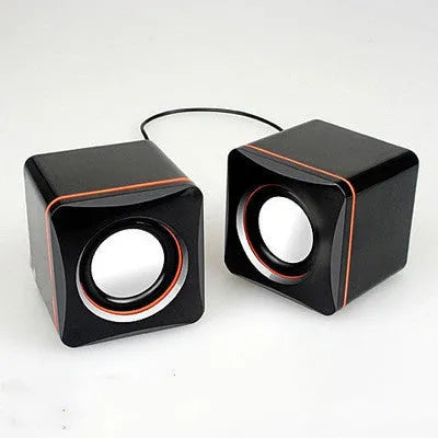 Small square black USB-powered 2.0 desktop computer speaker on a desk.