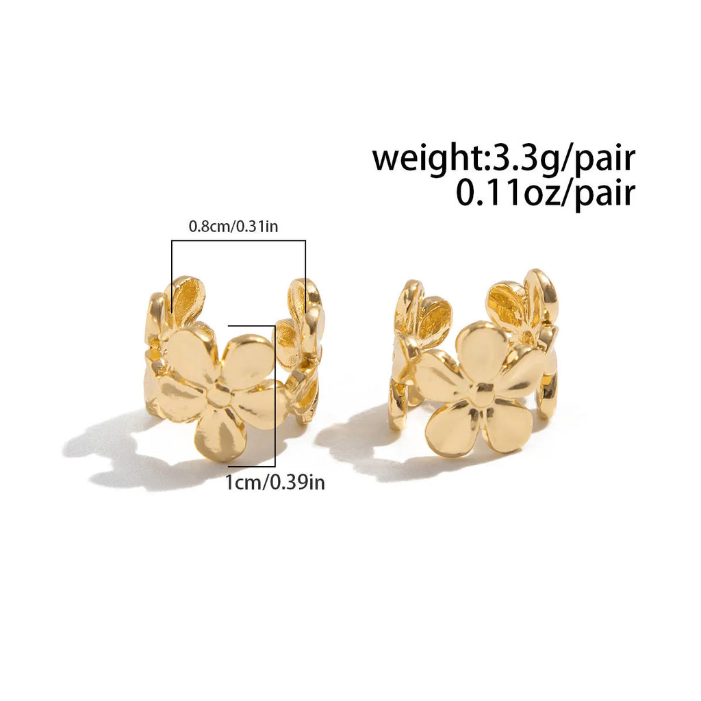 Gold coloured starfish and conch drop earrings on a white background.