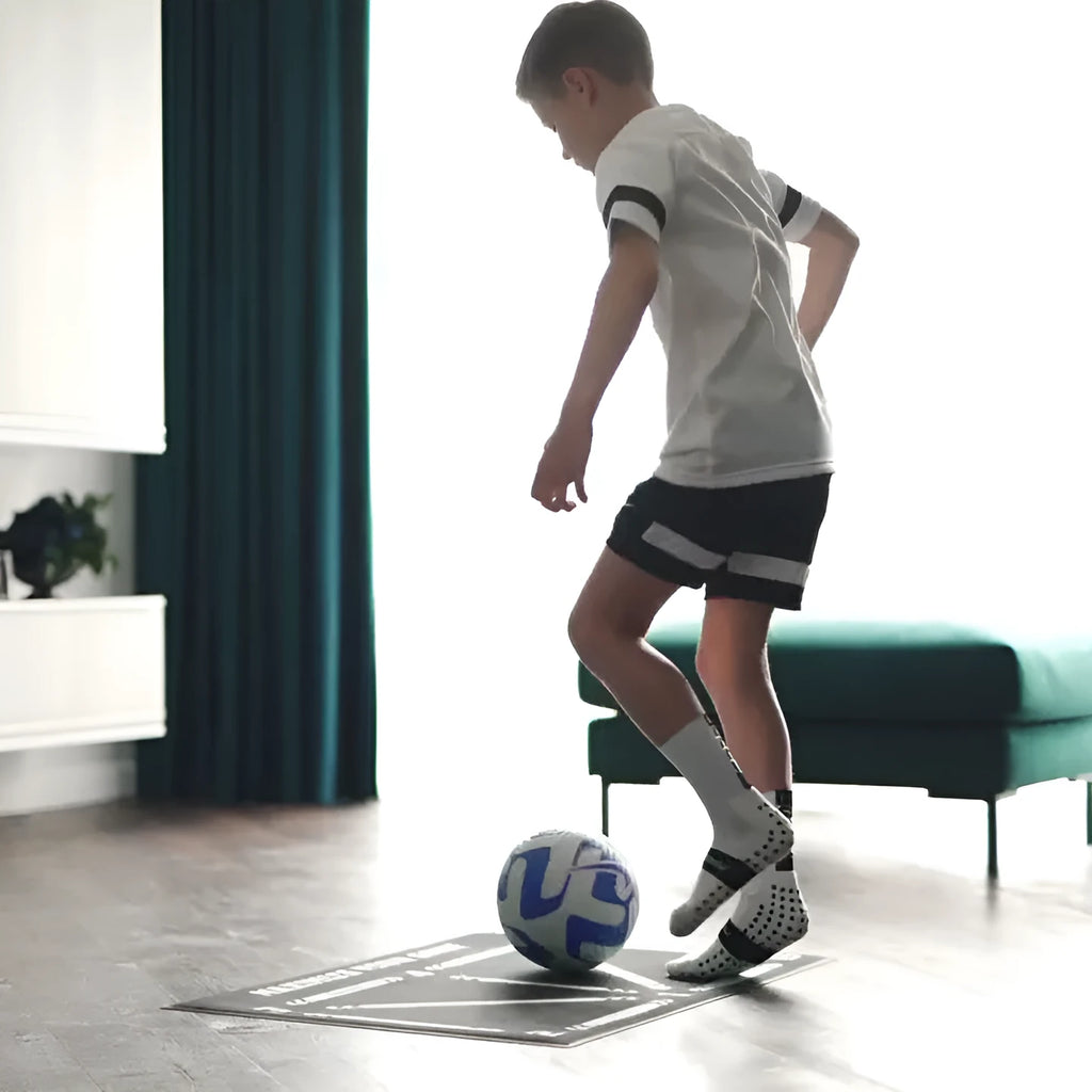 Black non-slip football training mat measuring 60cm by 90cm on a flat surface