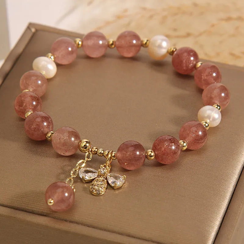Women's bracelet with strawberry quartz beads, three freshwater pearls, and sparkling zircon details on a metal chain.