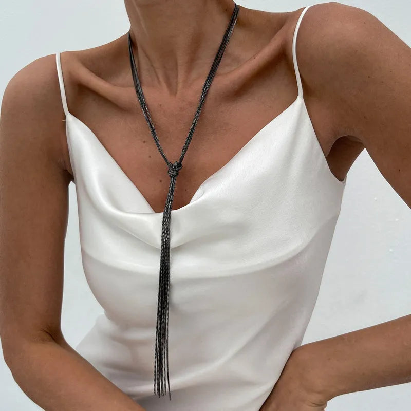 Simple Y-shaped metal tassel necklace in gold finish on a woman, with matching earrings, minimalist style for commuting wear