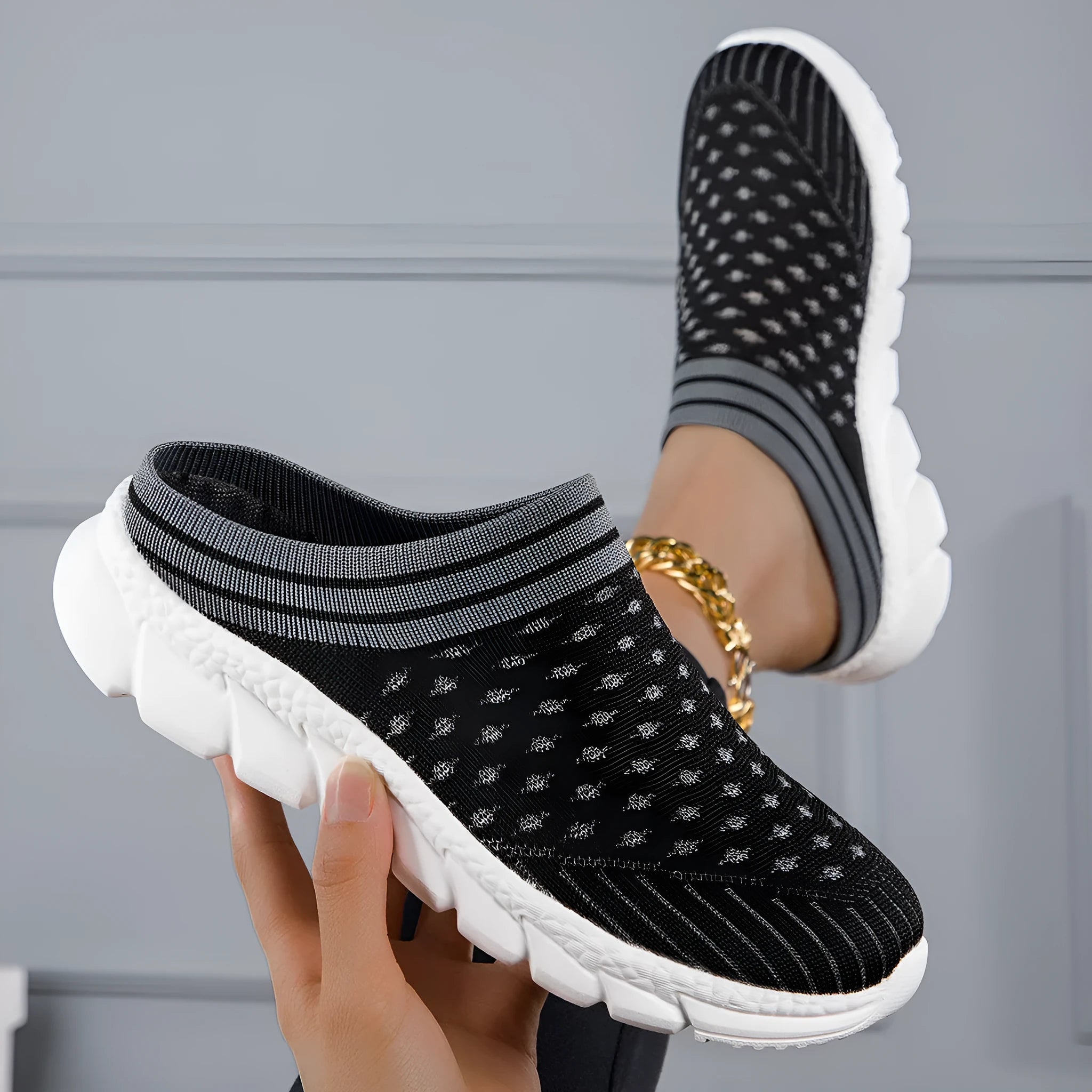 Women's black Flyknit semi-slipper casual shoe with striped pattern and hollow-out design on a white background.