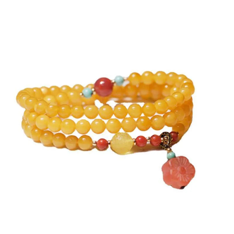 Yellow amber chicken grease beeswax bracelet with 5mm beads and Zodiac modelling on a wrist.