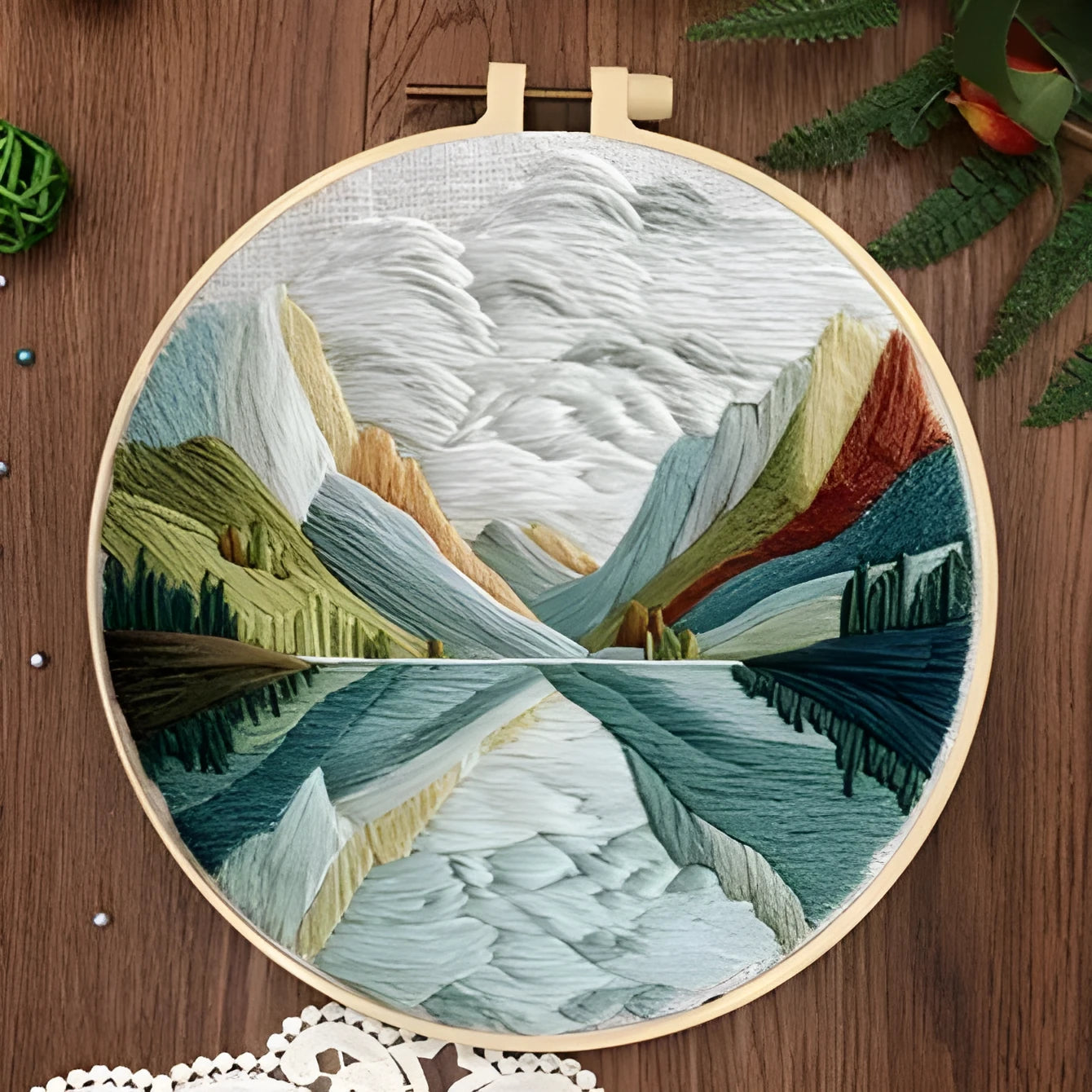 Embroidery DIY kit with landscape designs on cotton fabric, bamboo frame, thread, and needles