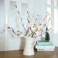 Pink Phalaenopsis-shaped LED decorative light with a bendable 65cm fabric branch on a wooden table.