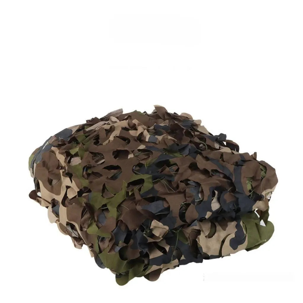 Green camouflage netting on a forest floor showing a multi-spot camouflage pattern.