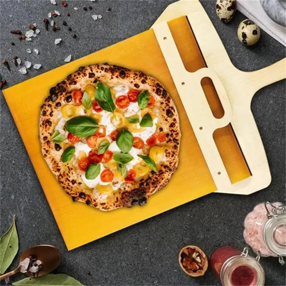 White food-grade PP plastic pizza transfer shovel with a hanging hole, shown on a kitchen counter.