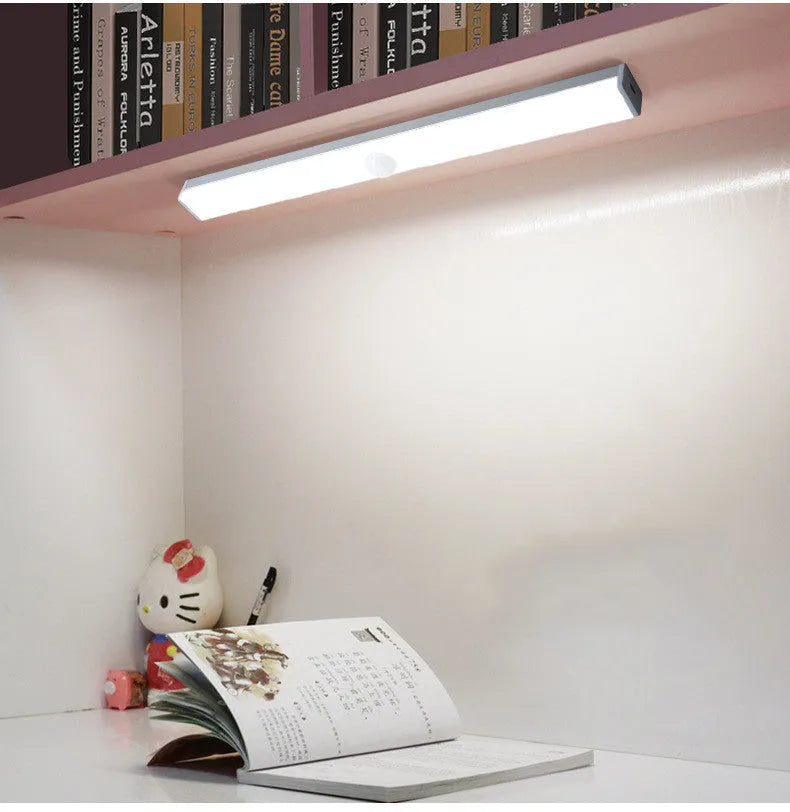 Black battery-powered LED strip light with motion sensor for cabinet or staircase installation.