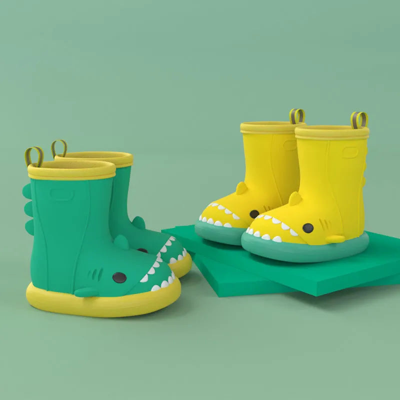Shark brand children's green rain boots with a dinosaur graphic, showing medium height and plastic construction.