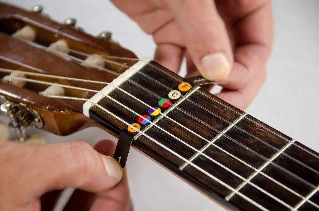 Guitar fretboard note stickers on acoustic guitar fingerboard showing note labels