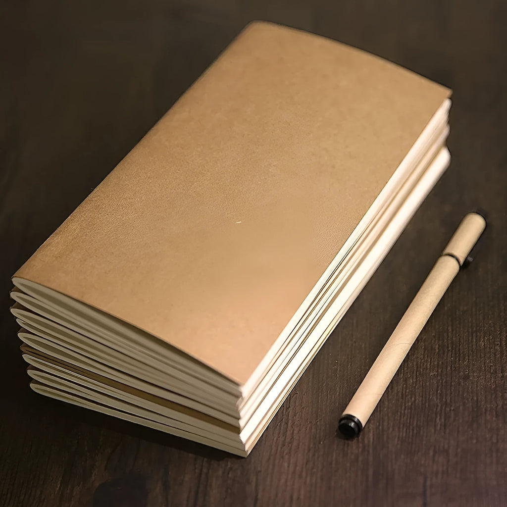 Kraft paper travel diary notebook open on a table, 110x210mm, with saddle stitching and lined interior pages