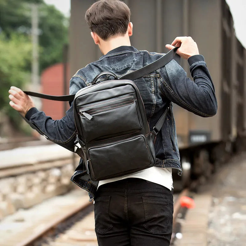 Large black cowhide leather backpack with vertical square shape and shoulder straps