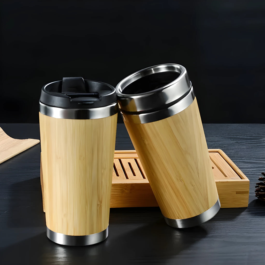Bamboo travel coffee cup with stainless steel interior, leak-proof lid, and a grey foam pad.