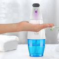 White intelligent induction foam machine on countertop with hand under nozzle dispensing foam