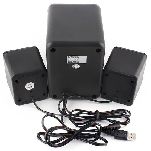 Green 2.1 USB computer speaker with LED lights on a desk next to a laptop.
