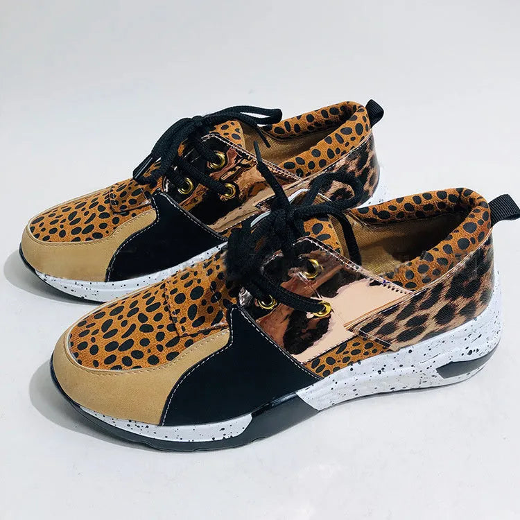 Women's black suede casual sneakers with a low wedge heel and round toe on a white background.