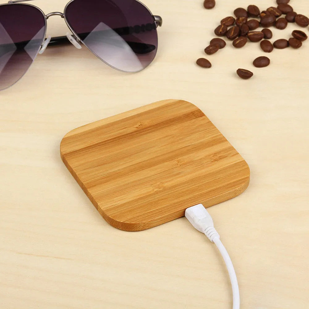 Square brown wooden bamboo 5W Qi wireless charging pad on a table