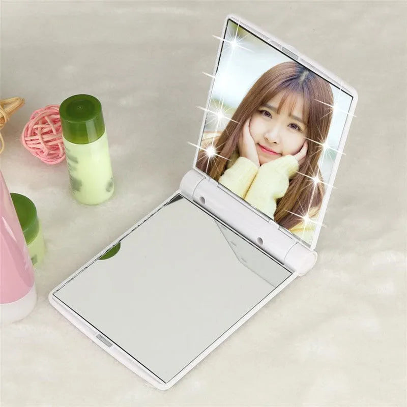 Folding LED pocket cosmetic mirror in black with built-in light, closed position