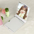 Folding LED pocket cosmetic mirror in black with built-in light, closed position