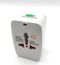 White universal travel plug adapter on a grey background showing its compact size.