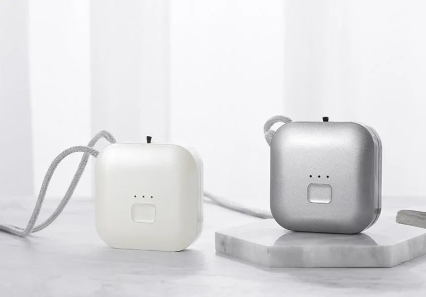 Compact USB-powered air purifier necklace in pink, showing wearable design and one-button control.