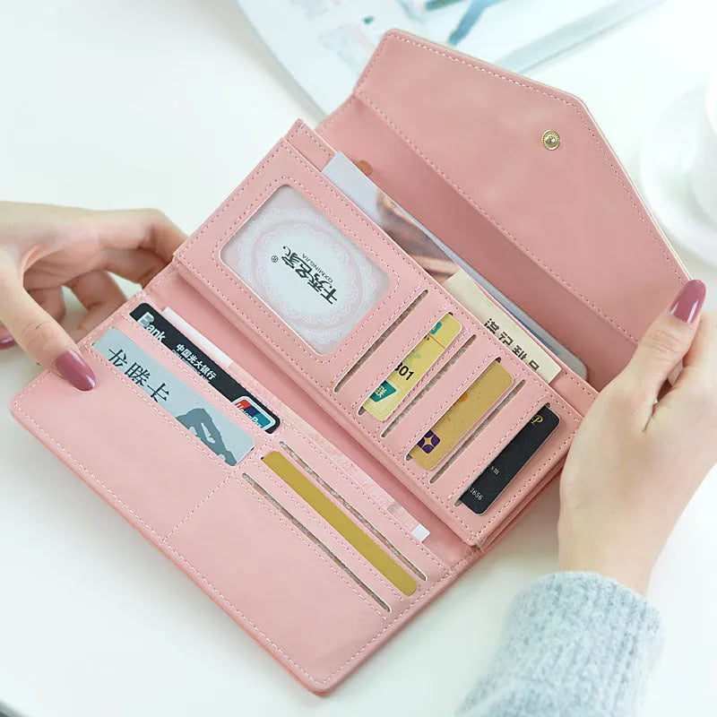 Women's black three-fold PU leather wallet with a buckle closure, shown open to display multiple card slots.