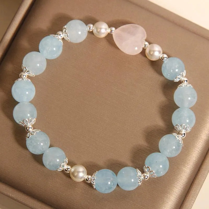 Natural aquamarine crystal bracelet with three shell pearls and lobster clasp on display