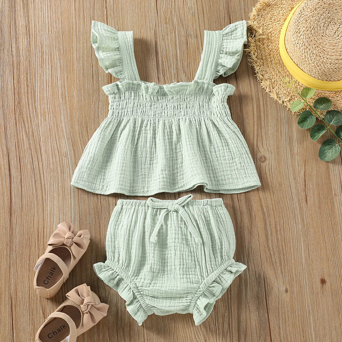 Green cotton girls' two-piece set with sleeveless sling top and matching short hot pants.